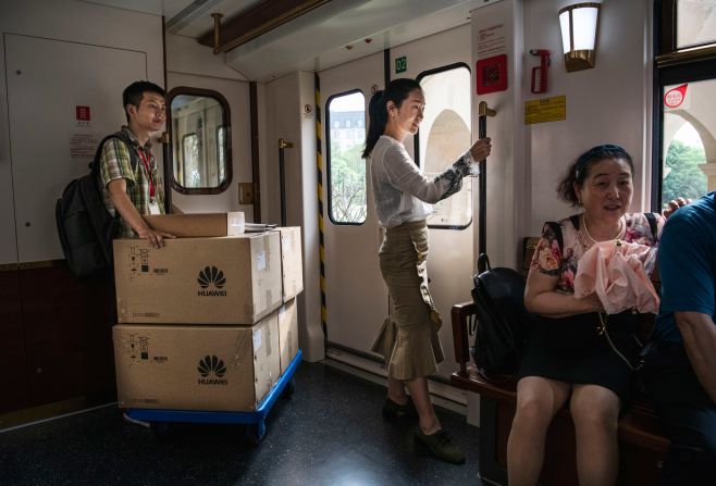 Un trabajador de Huawei transporta cajas en un tren utilizado por empleados, clientes y visitantes en el campus de Dongguan.