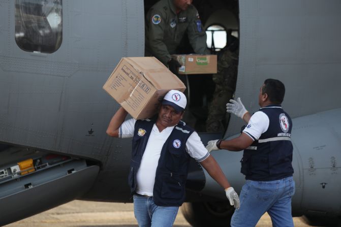 Miembros de una brigada de salud descargan cajas con suministros médicos de un avión, que se utilizarán en las áreas afectadas por el terremoto que afectó el norte de Perú.