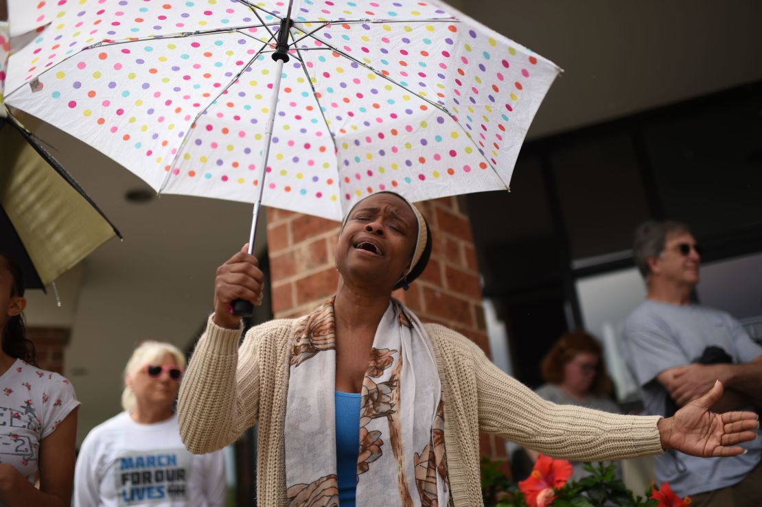 Una vecina ora el 1 de junio de 2019 por las víctimas del tiroteo masivo, durante una vigilia improvisada en un estacionamiento de un centro comercial en Virginia, Beach, Virginia.