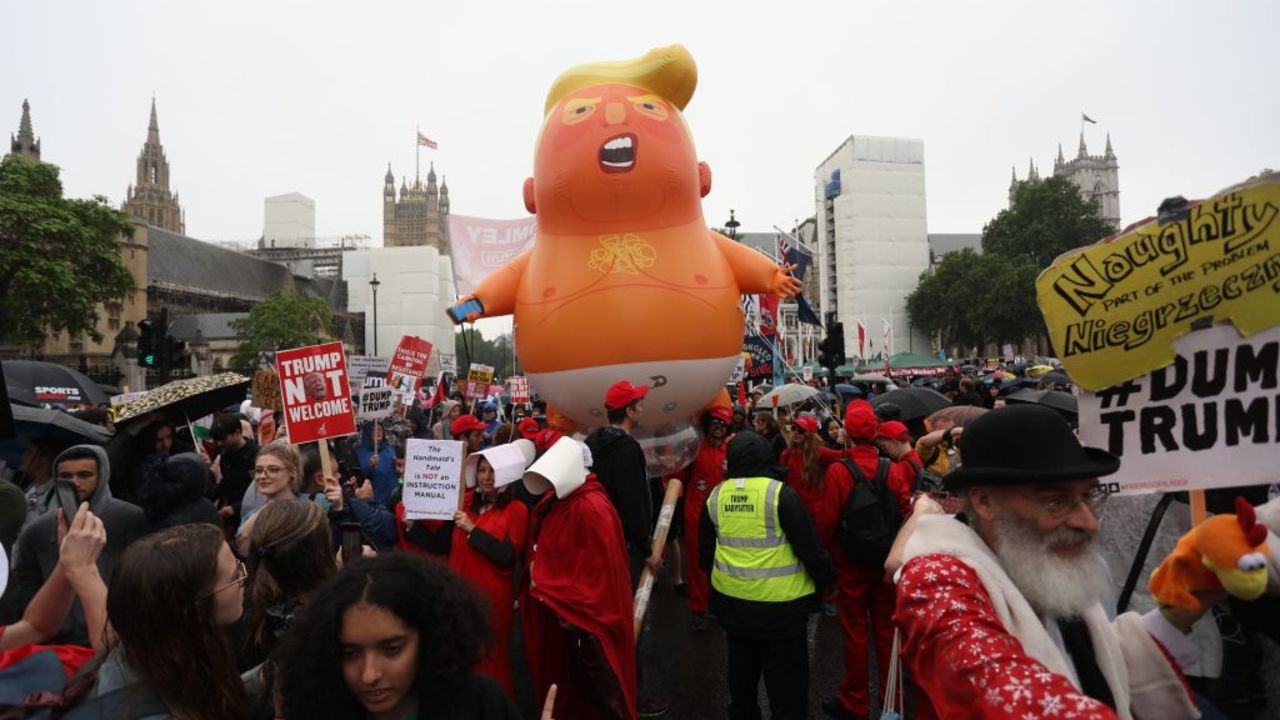 A giant balloon depicting US President Donald Trump as an orange baby floats above anti-Trump demonstrators in Parliament Square outside the Houses of Parliament in London on June 4, 2019, on the second day of Trump's three-day State Visit to the UK. - US President Donald Trump turns from pomp and ceremony to politics and business on Tuesday as he meets Prime Minister Theresa May on the second day of a state visit expected to be accompanied by mass protests. (Photo by ISABEL INFANTES / AFP)