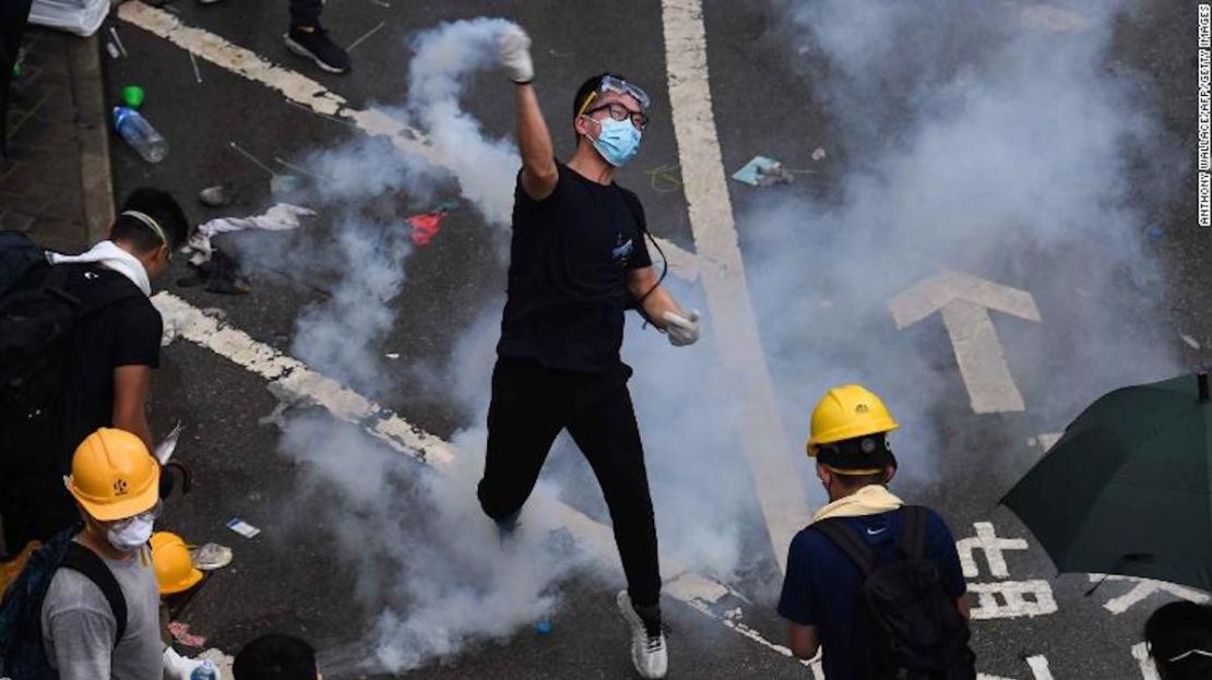 Un manifestante regresa una lata de gas lacrimógeno que lanzó la Policía a las afueras de la sede del Gobierno de Hong Kong. (Anthony WALLACE / AFP).