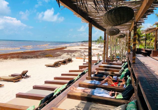 Turistas se broncean en una playa de Tulum mientras toneladas de sargazo llegan a las costas mexicanas.