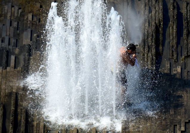 Un hombre se refresca en una fuente en el Lustgarten, en el centro de Berlín.