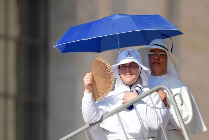 Dos monjas se protegen del sol mientras esperan la audiencia general del papa Francisco en el Vaticano.