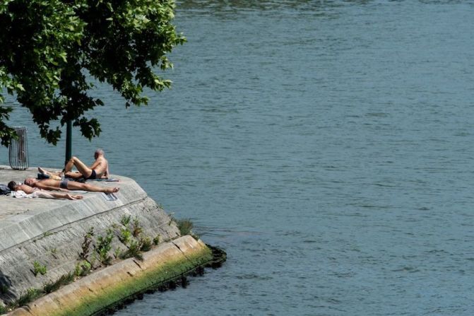 Personas toman el sol en la orilla del río Sena, en París.