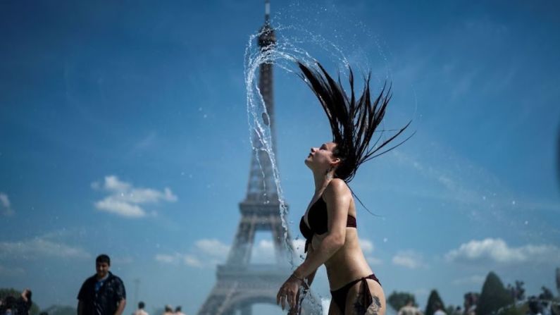 Una mujer se refresca en la fuente de la explanada de Trocadero, en París.