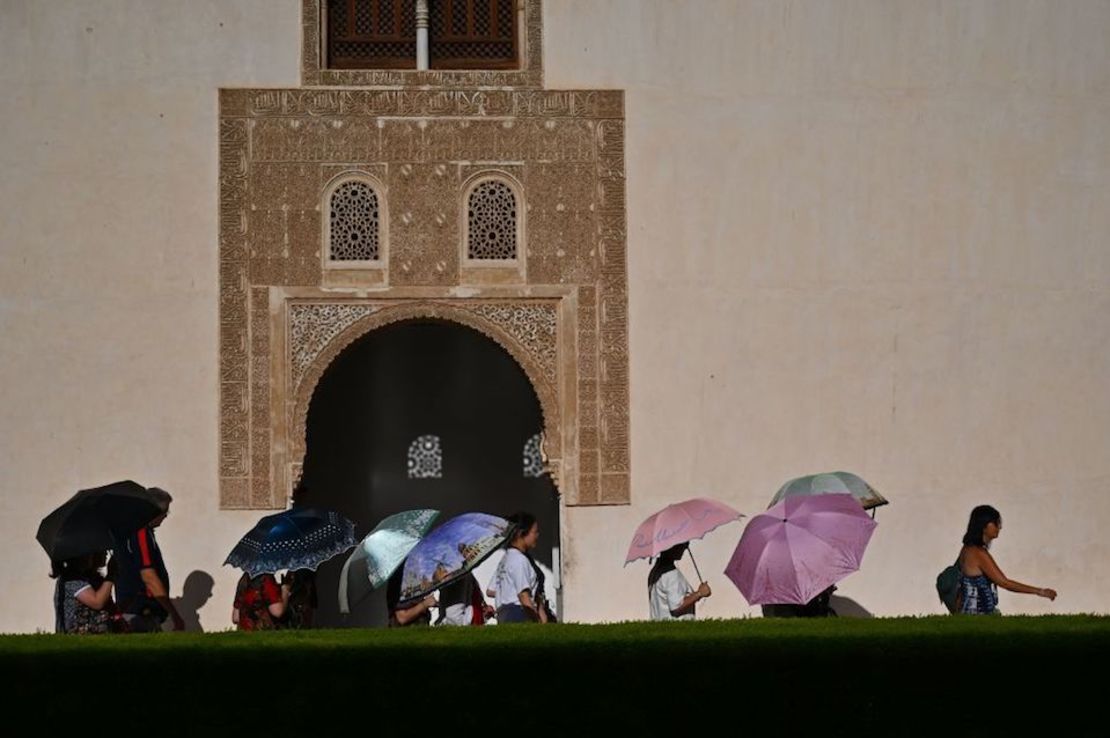 Turistas se protegen del sol durante su visita a La Alhambra, en Granada, España. GABRIEL BOUYS/AFP/Getty Images)