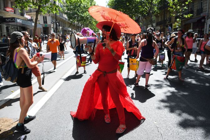 Francia. Un participante se refugia bajo un paraguas y usa un megáfono durante el desfile anual del Orgullo Gay, realizado este domingo en París.