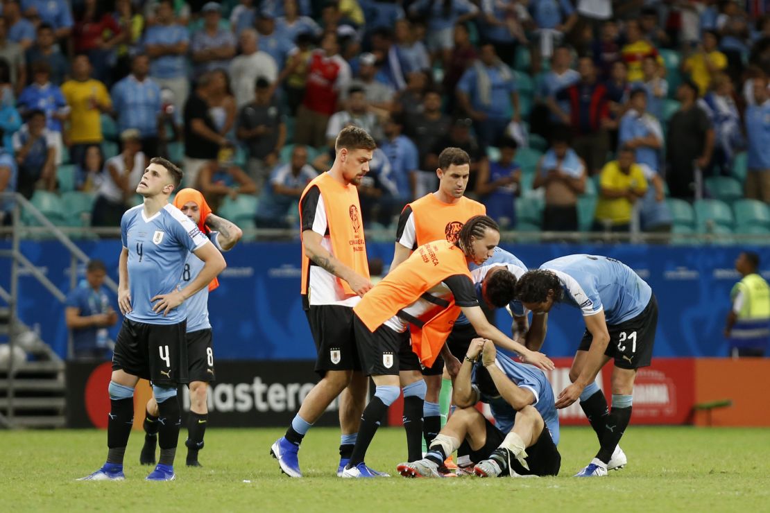 Jugadores de Uruguay buscan consolar a Luis Suárez, quien erró su tiro en ronda de penaltis.