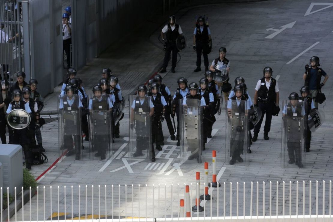 Agentes de la Policía hacen guardia en la sede del Consejo Legislativo de Hong Kong mientras manifestantes violentos intentan irrumpir en el edificio el 1 de julio de 2019. (VIVEK PRAKASH/AFP/Getty Images).