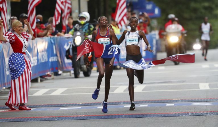 Brigid Kosgei, a la izquierda, cruza la línea final antes que Agnes Tirop para ganar la carrera anual Peachtree Road en Atlanta.