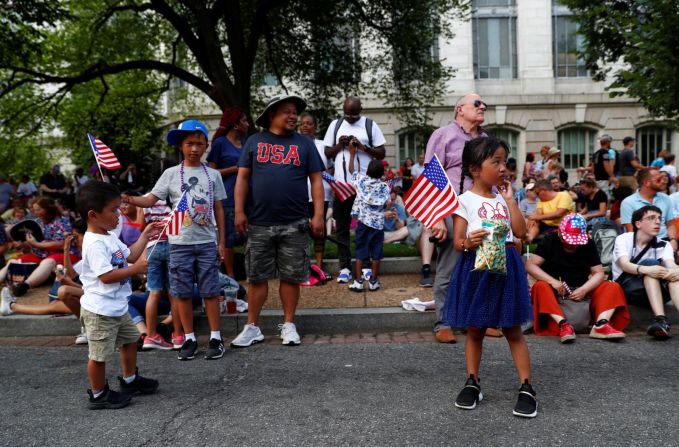 Espectadores enarbolan banderas mientras miran las celebraciones en Washington.