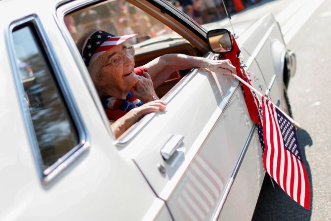 Mabel Wittenmeyer, de 93 años, sonríe a los espectadores mientras va en un auto en el desfile del Barnstable Village en Massachusetts.