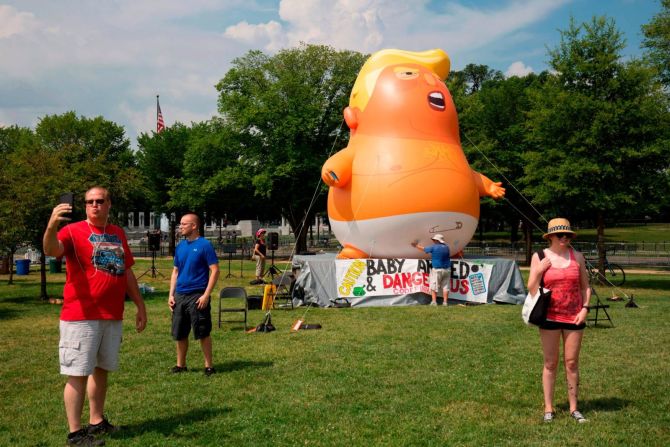 Gente se toma fotos frente a un globo de "Bebé Trump" instalado por miembros del grupo Code Pink (Código Rosa) en Washington.