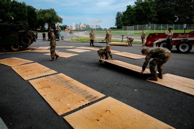 Personal militar instala madera contrachapada mientras un tanque es conocido hacia el frente del Monumento a Lincoln antes del evento "Saludo a EE.UU." del presidente Trump en Washington.