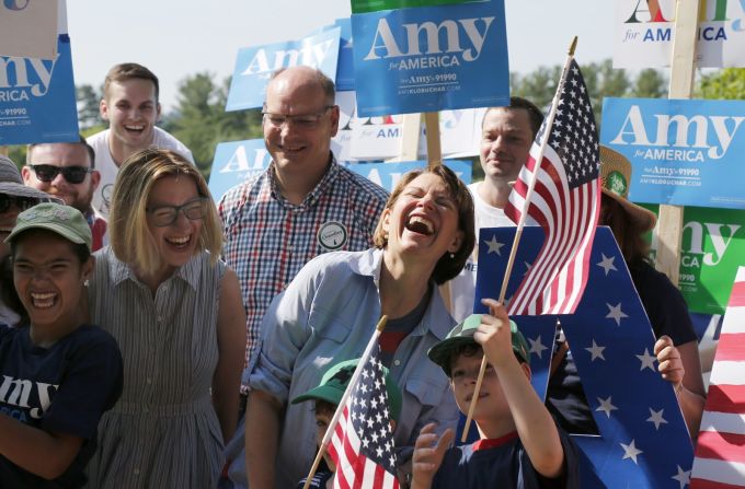 La aspirante demócrata Amy Klobuchar, en la camisa azul, ríe durante el desfile del 4 de julio en Amherst, Massachusetts.