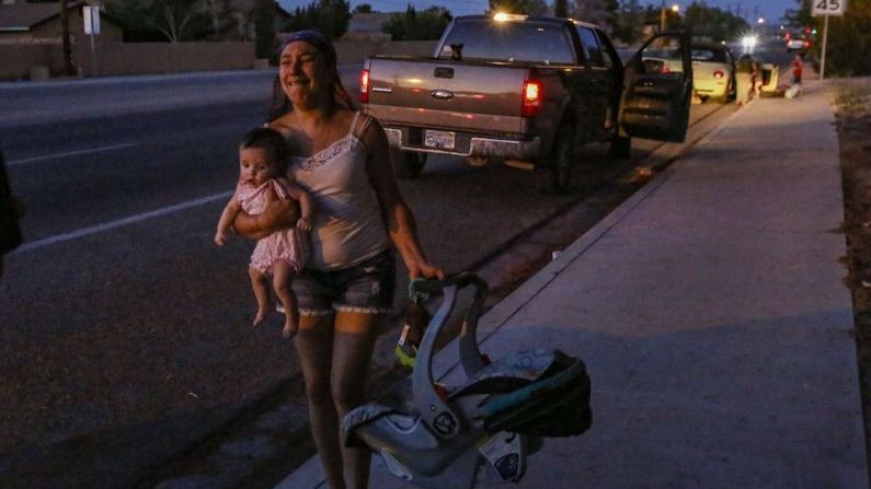 Dawn Inscore sale corriendo de su apartamento con su hijo después de que un sismo de magnitud 7,1 sacudiera Ridgecrest, California, el viernes 5 de julio de 2019.