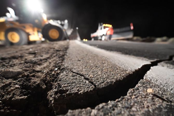 Trabajadores reparan un agujero en una carretera que se abrió como resultado del sismo del 5 de julio en Ridgecrest, California.