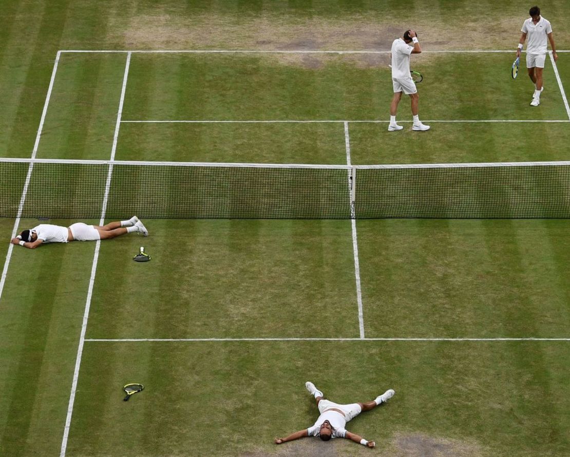 Los colombianos Juan Sebastián Cabal (en el piso al fondo de cancha) y Robert Farah (en el piso a la izquierda) celebran después de vencer a los franceses Nicolas Mahut y Edouard Roger-Vasselin durante la final de dobles masculinos el día doce del Campeonato de Wimbledon 2019 (DANIEL LEAL-OLIVAS / AFP / Getty Images).