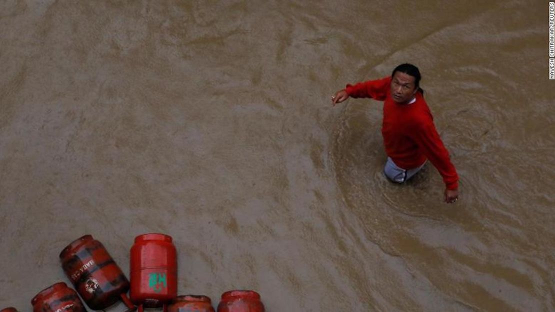 Un hombre pasa junto a los cilindros de gas en una colonia inundada en Katmandú, Nepal, el 12 de julio de 2019.