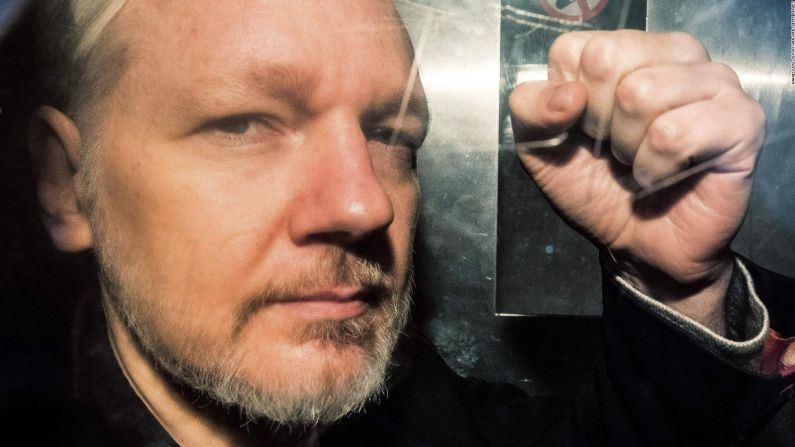Assange hace un gesto desde la ventana de una camioneta de la prisión mientras lo conducen al Southwark Crown Court en Londres el 1 de mayo de 2019, antes de ser sentenciado a 50 semanas de prisión por violar las condiciones de su libertad bajo fianza en 2012.