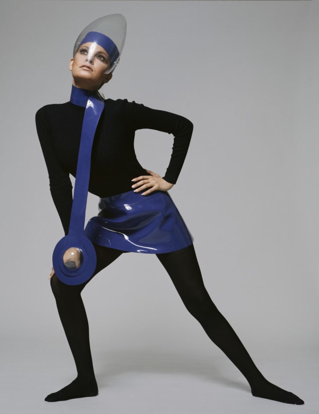 La actriz Raquel Welch, fotografiado por Terry O'Neill, en un atuendo de Pierre Cardin con una minifalda y un collar en vinilo azul, usado con una visera de plexiglás, 1970.