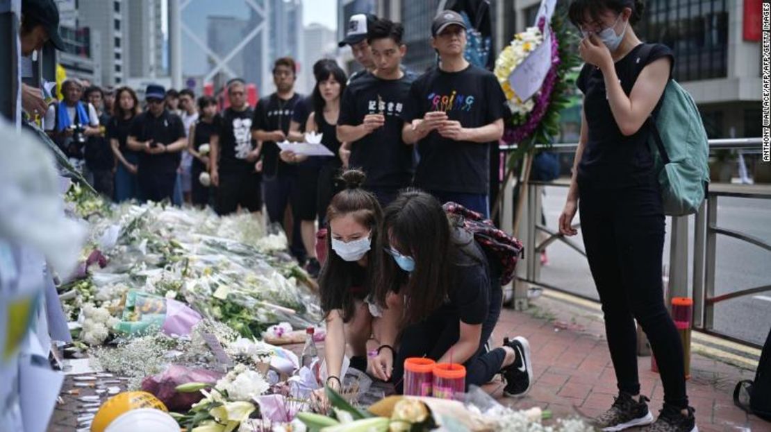 Los dolientes en Hong Kong ponen flores y ofrecen oraciones el 16 de junio de 2019, en el sitio donde murió un manifestante.