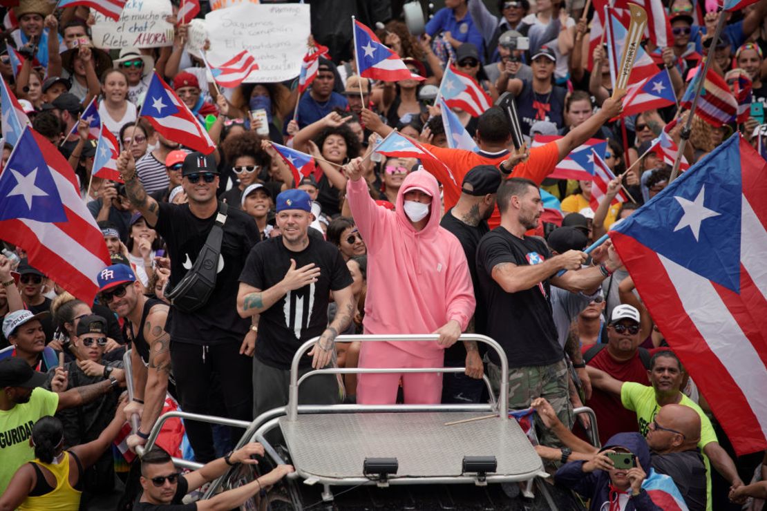 Residente (i) y Bad Bunny (centroderecha) se unen a los manifestantes en San Juan este jueves para celebrar la renuncia de Rosselló.