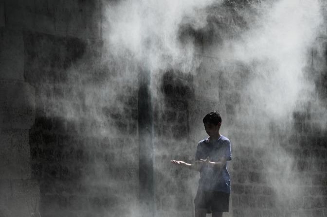 Un niño se refresca bajo un spray de rocío público cerca al río Sena en París, el 25 de julio. Foto: Philippe Lopez/AFP/Getty Images