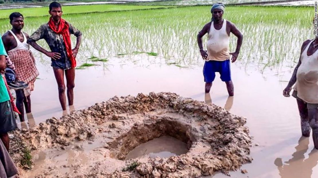 Aldeanos y agricultores posan alrededor del cráter dejado por un supuesto meteorito que cayó en la India.