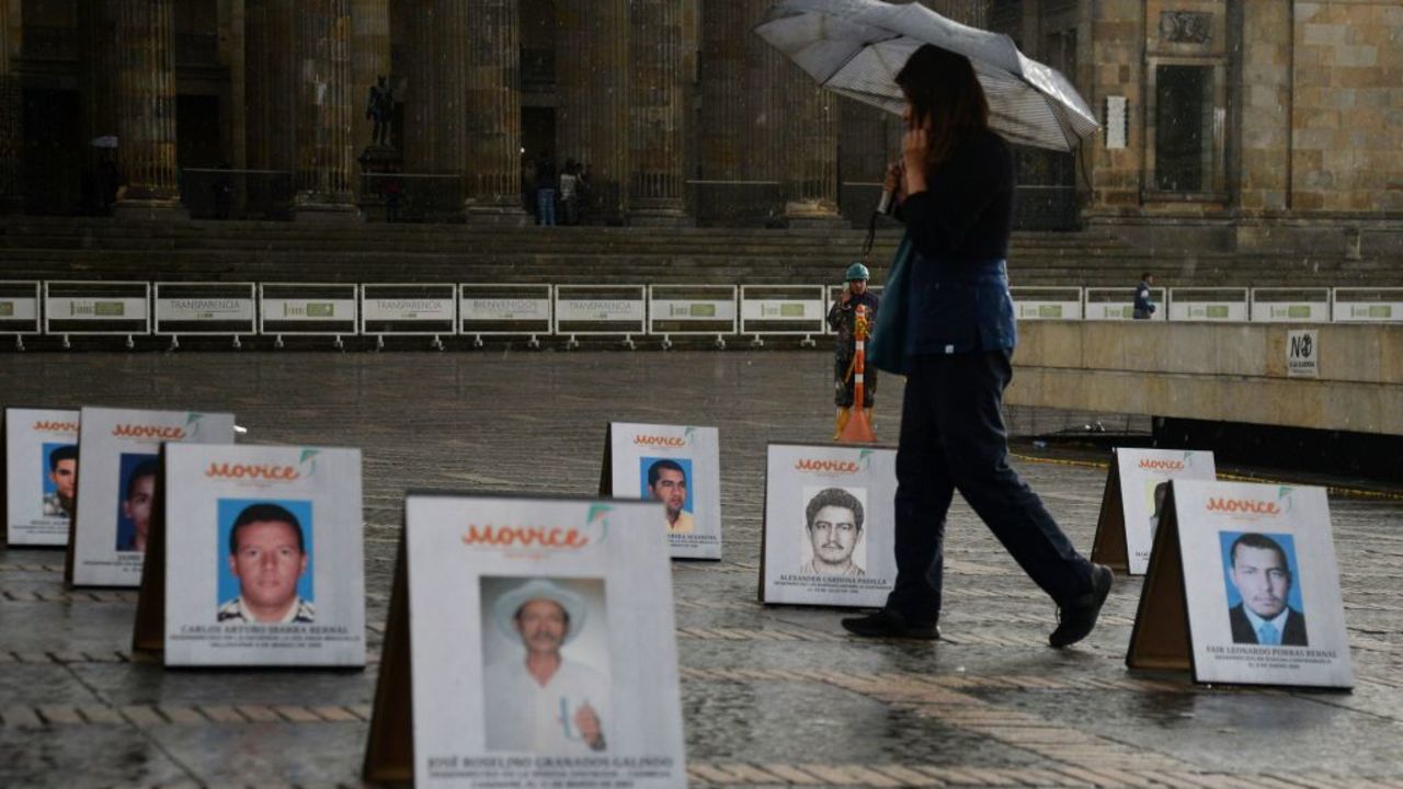 Una mujer camina entre los retratos de algunos de los cientos de líderes sociales asesinados entre 2018 y 2019 en Colombia, durante un protesta en su honor en la Plaza de Bolívar en Bogotá.