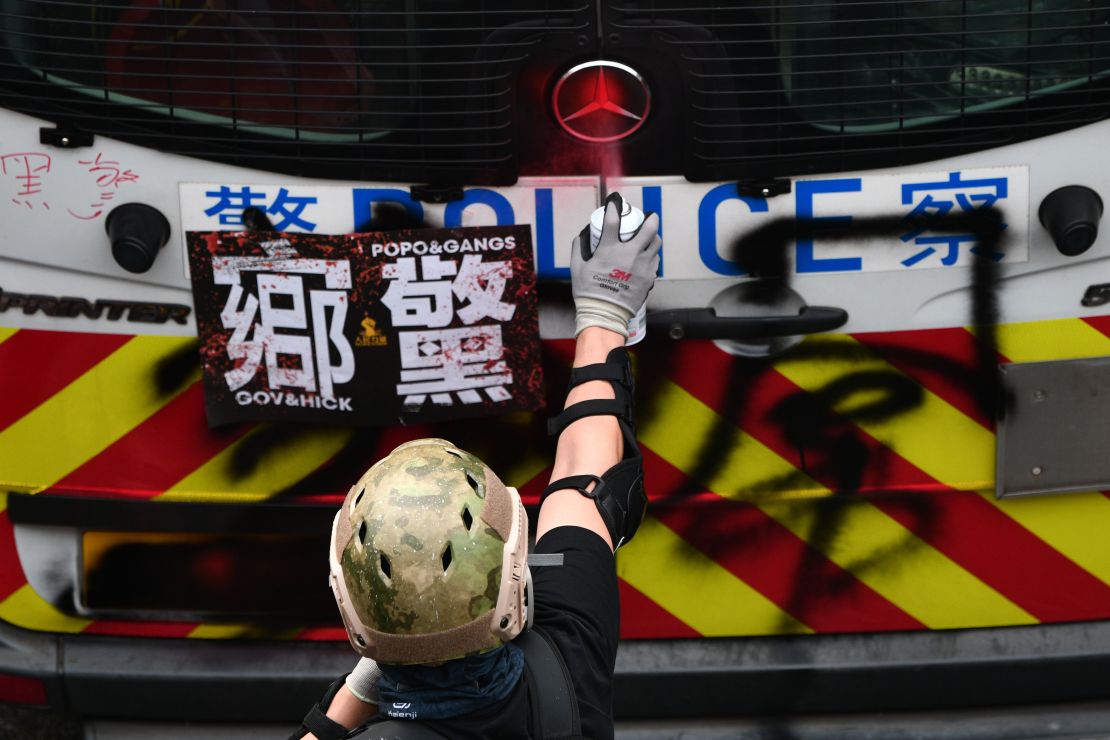 Un manifestante pinta con spray la parte trasera de una camioneta de la policía de Hong Kong, durante una manifestación en el distrito de Yuen Long.