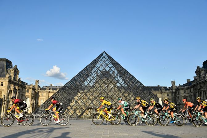 El colombiano Egan Bernal pasa con el resto de ciclistas por la icónica pirámidel del Museo del Louvre, en París.