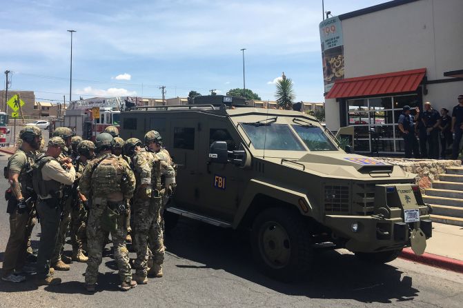 Policías armados se reúnen al lado de un vehículo blindado del FBI al lado del Centro Comercial Cielo Vista, mientras ocurre un tiroteo en el centro comercial de El Paso, Texas.