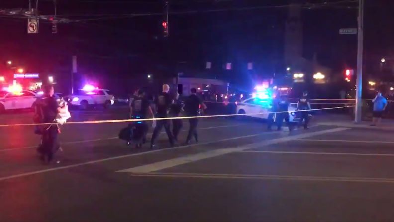 Esta captura de video tomada de la cuenta de Twitter de Derek Myers el 4 de agosto de 2019 muestra a los agentes policiales caminando detrás del cordón policial luego de un tiroteo masivo en el popular distrito de Oregon, en Dayton, Ohio.