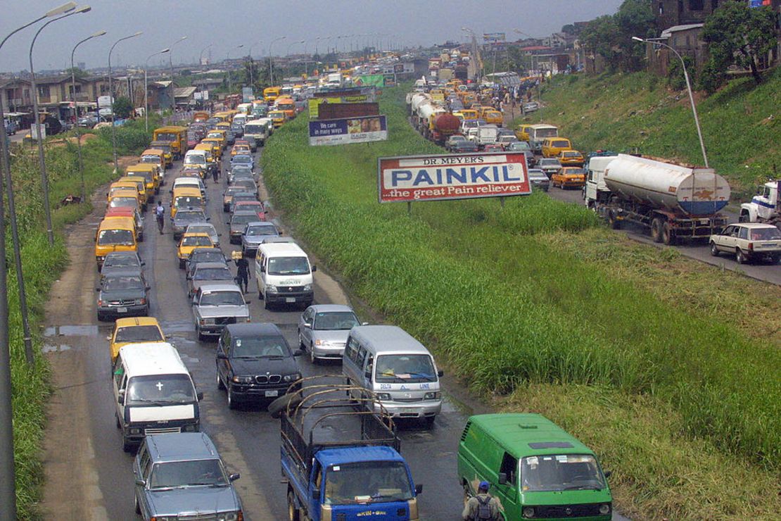 LAGOS, NIGERIA:  Motorists trapped in flooded Lagos roads crawl to their destinations in a severe traffic jam  17 June 2004.  A torrential rainfall which caused serious flooding in Lagos roads and leaving hundreds of buildings and properties submerged, almost grounded commercial activities in Nigeria's economic capital Lagos as most workers drove late to their offices following severe traffic jam on the roads. AFP PHOTO/PIUS UTOMI EKPEI