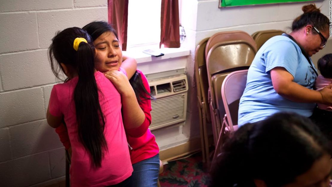 Edna Pérez, de 14 años, abraza a una de sus hermanas dentro del Trinity Mission Center en Forest, Mississippi. Su padre fue detenido y todavía está bajo custodia.