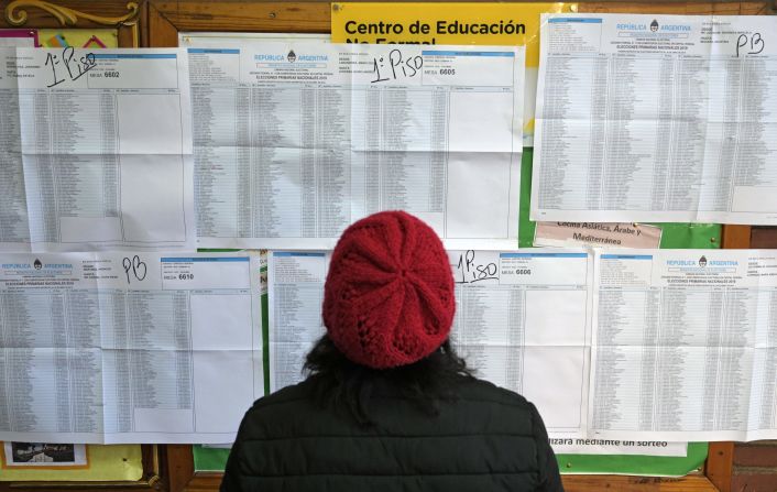 Una mujer busca su nombre en un padrón electoral, durante las elecciones primarias en Buenos Aires. Las elecciones primarias en Argentina tienen lugar el domingo, antes de la votación de octubre.