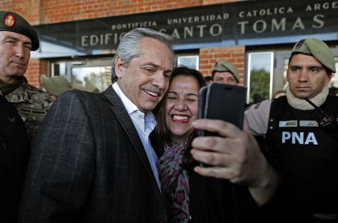 El candidato presidencial Alberto Fernández, del partido Frente de Todos, posa para una selfie con una seguidora, después de emitir su voto en un colegio electoral durante las elecciones primarias en Buenos Aires.