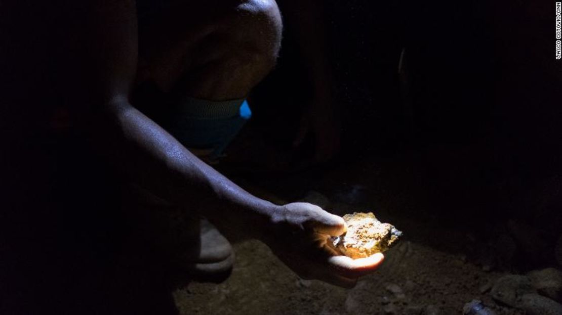 Un minero sostiene una pieza de roca, en lo profundo de una mina en el Arco Minero del Orinoco en Venezuela.