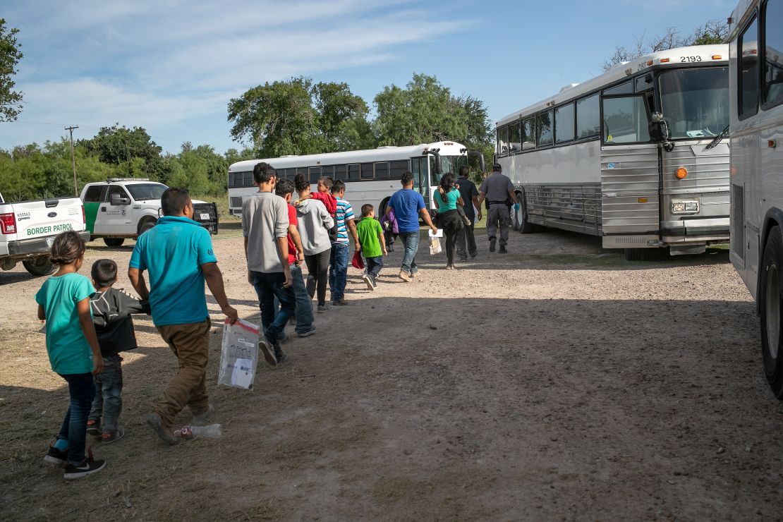 Un grupo de inmigrantes caminan hacia autobuses para ser transferidos a una instalación de la Patrulla Fronteriza en Texas.