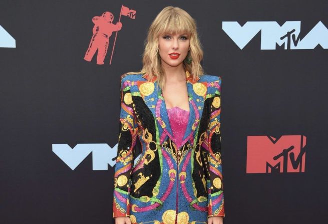 Taylor Swift llegó con un llamativo Versace, que combinó con unas botas altas Christian Louboutin. Se llevó dos premios VMA, incluyendo mejor Video del Año. Evan Agostini/Invision/AP