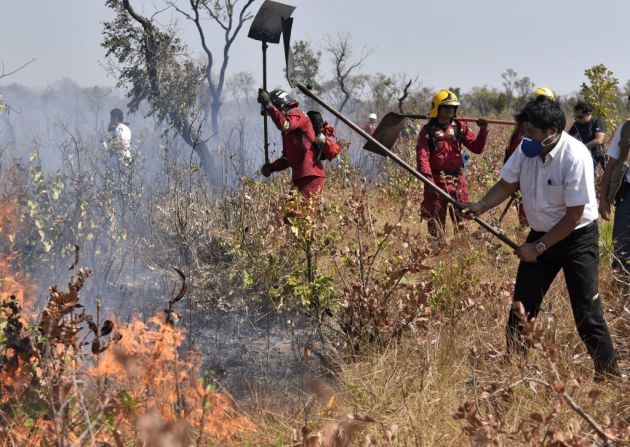 El presidente de Bolivia, Evo Morales, ayuda a los bomberos a tratar de controlar un incendio cerca de Charagua, Bolivia, en la frontera con Paraguay, al sur de la cuenca del Amazonas, el 29 de agosto de 2019.