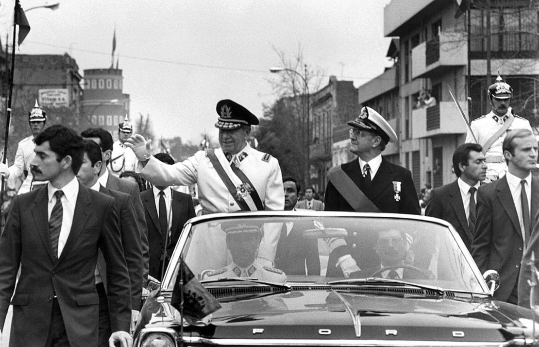 El dictador Augusto Pinochet (en el centro), líder de la junta militar chilena, saluda en una caravana el 11 de septiembre de 1973 en Santiago, poco después del golpe de Estado contra el presidente Salvador Allende. Un año después, en 1974, Pinochet firmó un decreto en el que se nombró presidente.