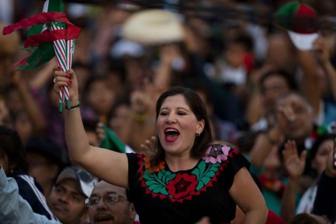 Con vestimenta típica y los colores de la bandera de México, la gente celebra la independencia.