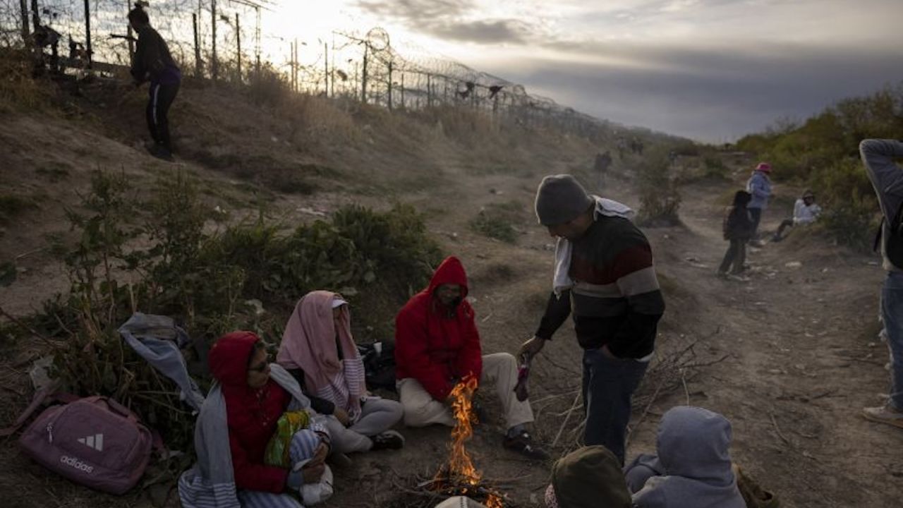 Migrantes de Venezuela sentados junto a una fogata improvisada mientras esperan para entrar y pedir asilo en El Paso, Texas, desde Ciudad Juárez, Chihuahua, México, el 2 de abril de 2024.