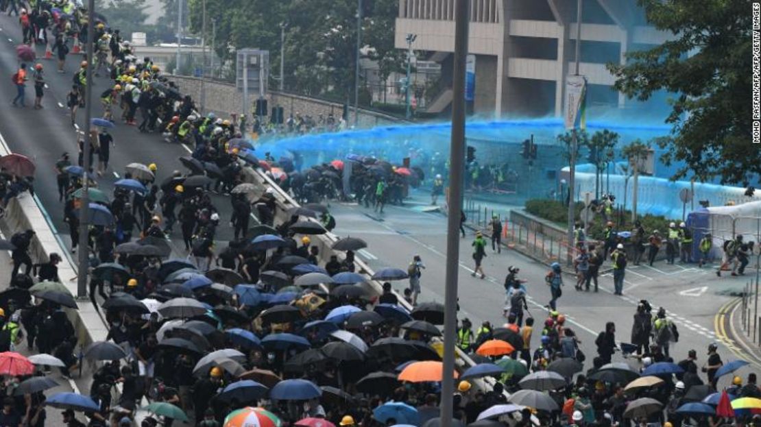 La policía de Hong Kong disparó un cañón de agua azul contra los manifestantes reunidos frente a las oficinas del gobierno central después de participar en una marcha no autorizada a través de Hong Kong el 29 de septiembre.