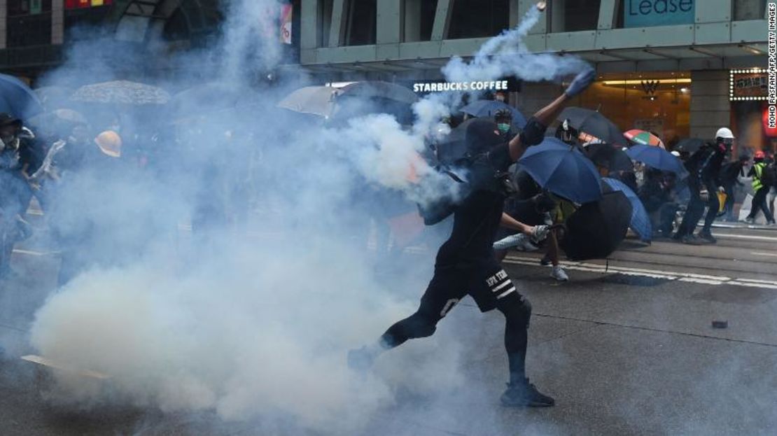 Un manifestante arroja un bote de gas lacrimógeno hacia la policía en el distrito de Wanchai en Hong Kong este domingo.