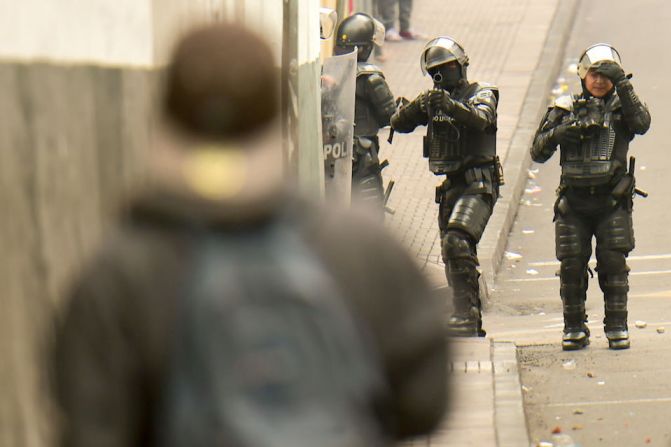 Policías antidisturbios enfrentan a manifestantes en Quito.