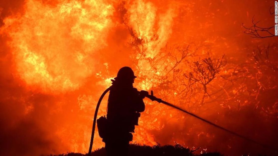 El incendio Saddleridge arde cerca de un bombero en Sylmar, California, el 10 de octubre de 2010.